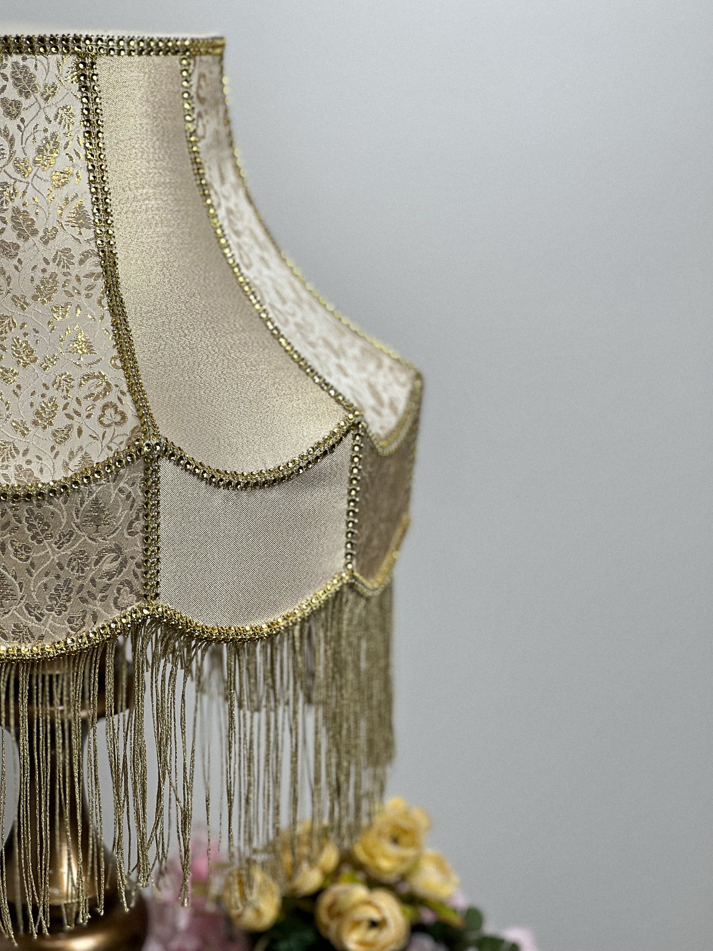 Gold-colored table lamp with elegant lace details and tasseled fringe. 7202