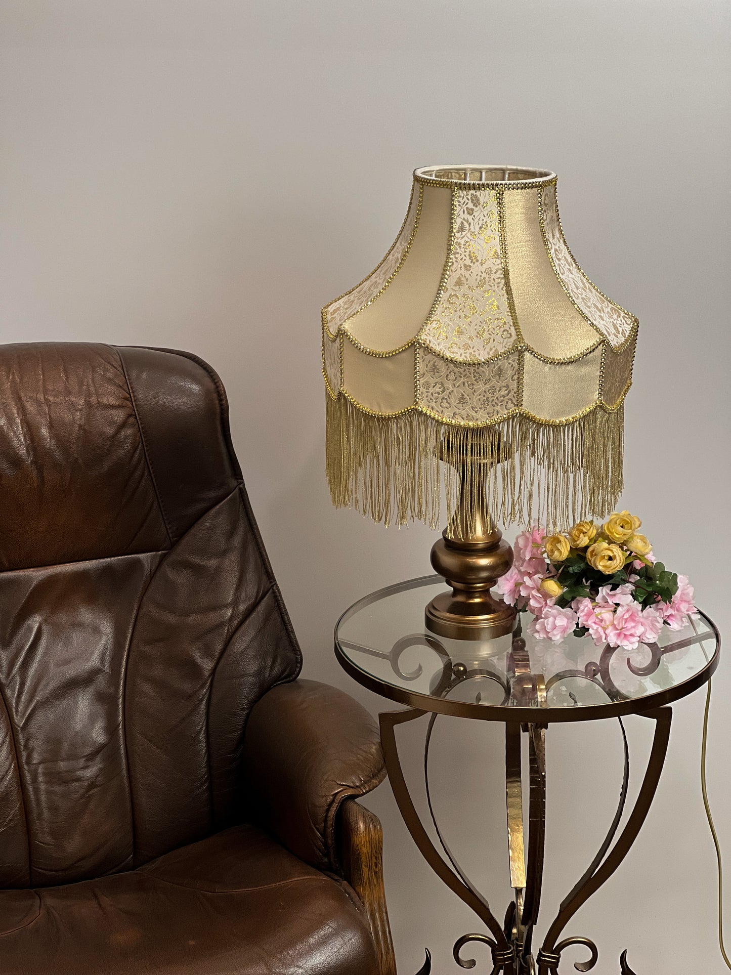Gold-colored table lamp with elegant lace details and tasseled fringe. 7202