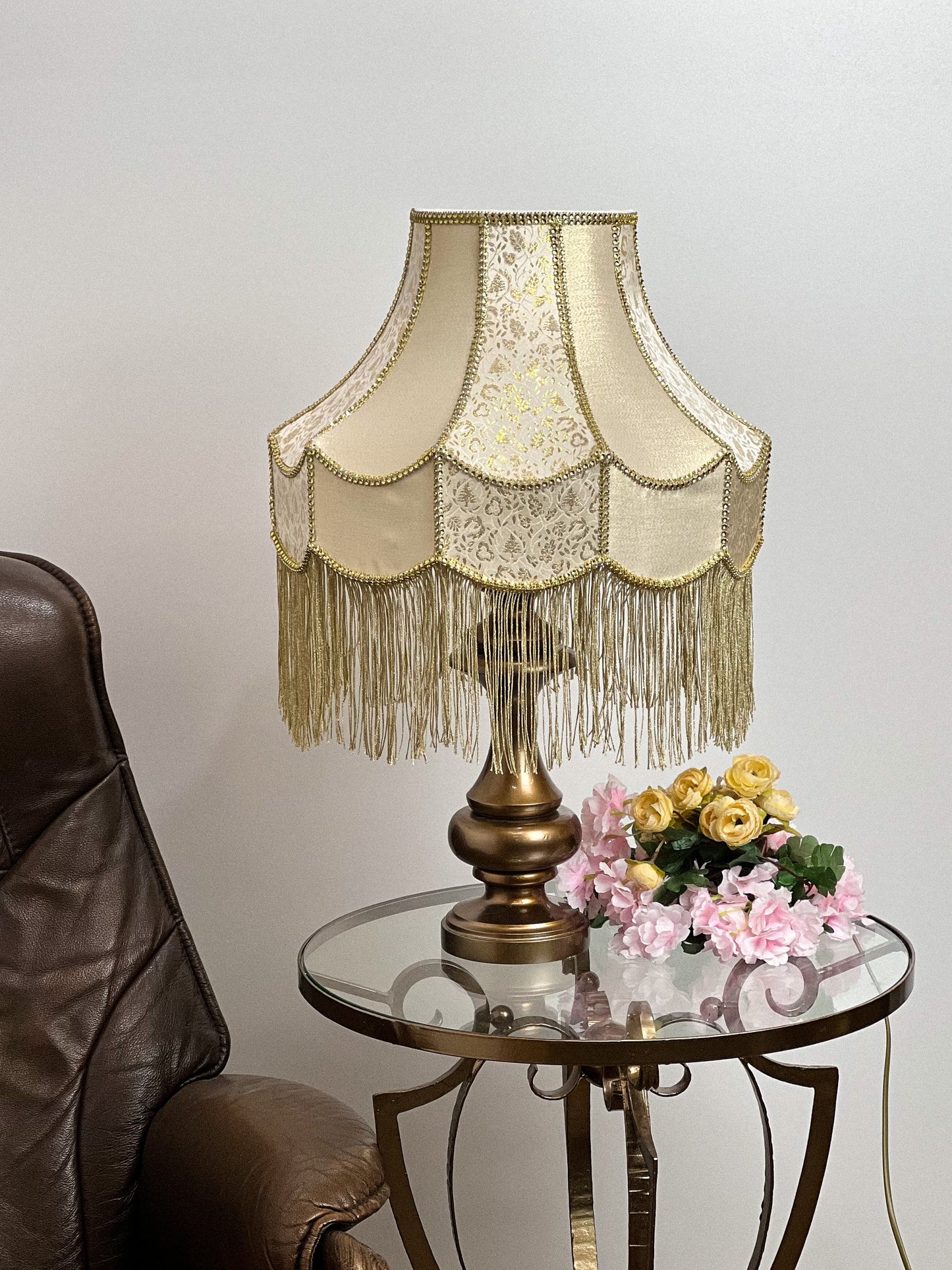 Gold-colored table lamp with elegant lace details and tasseled fringe. 7202