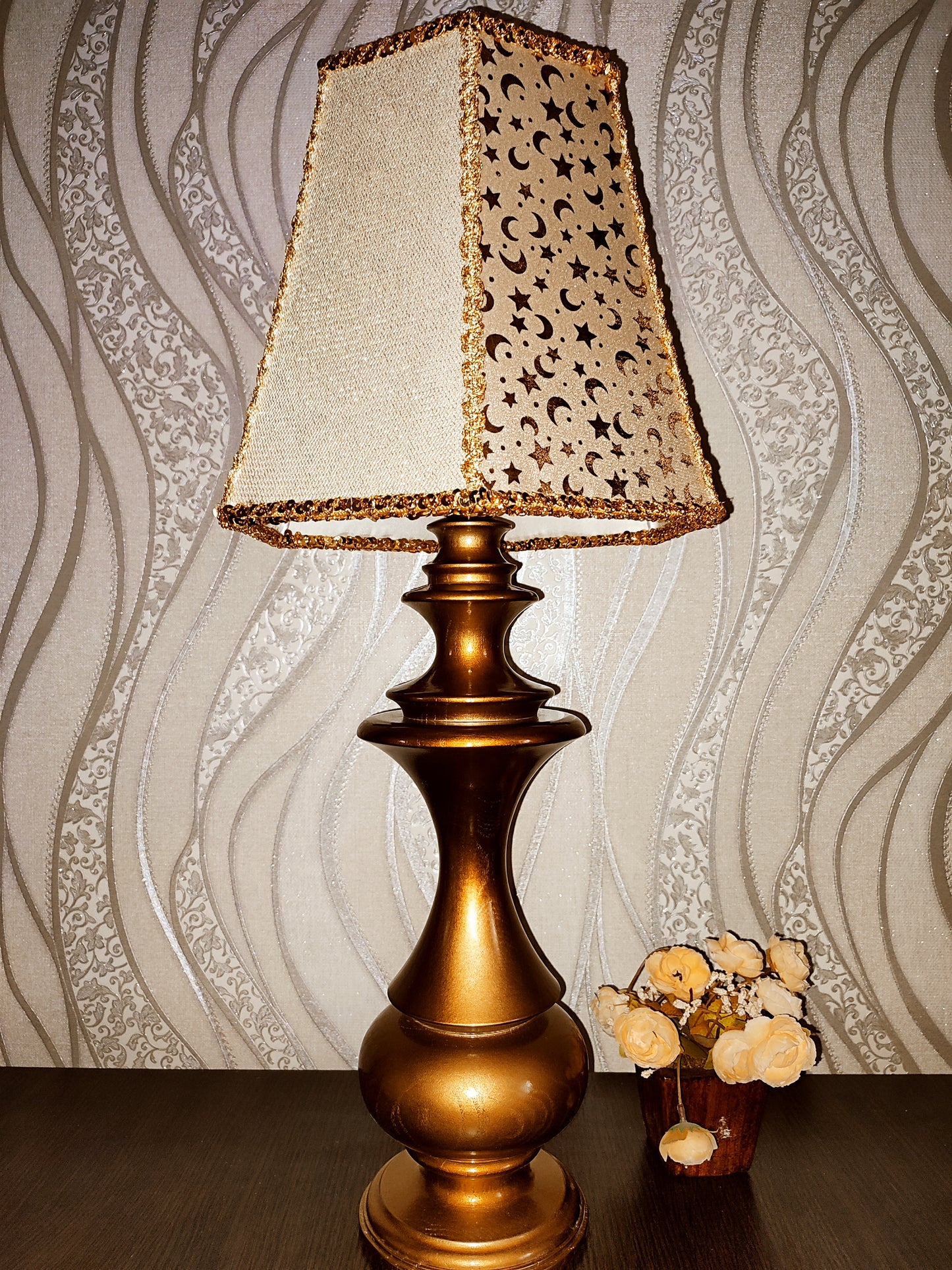 Table lamp. Golden celestial lamp with shimmering moons and stars on a delicate fabric. The wooden base is bronze in color. 7701