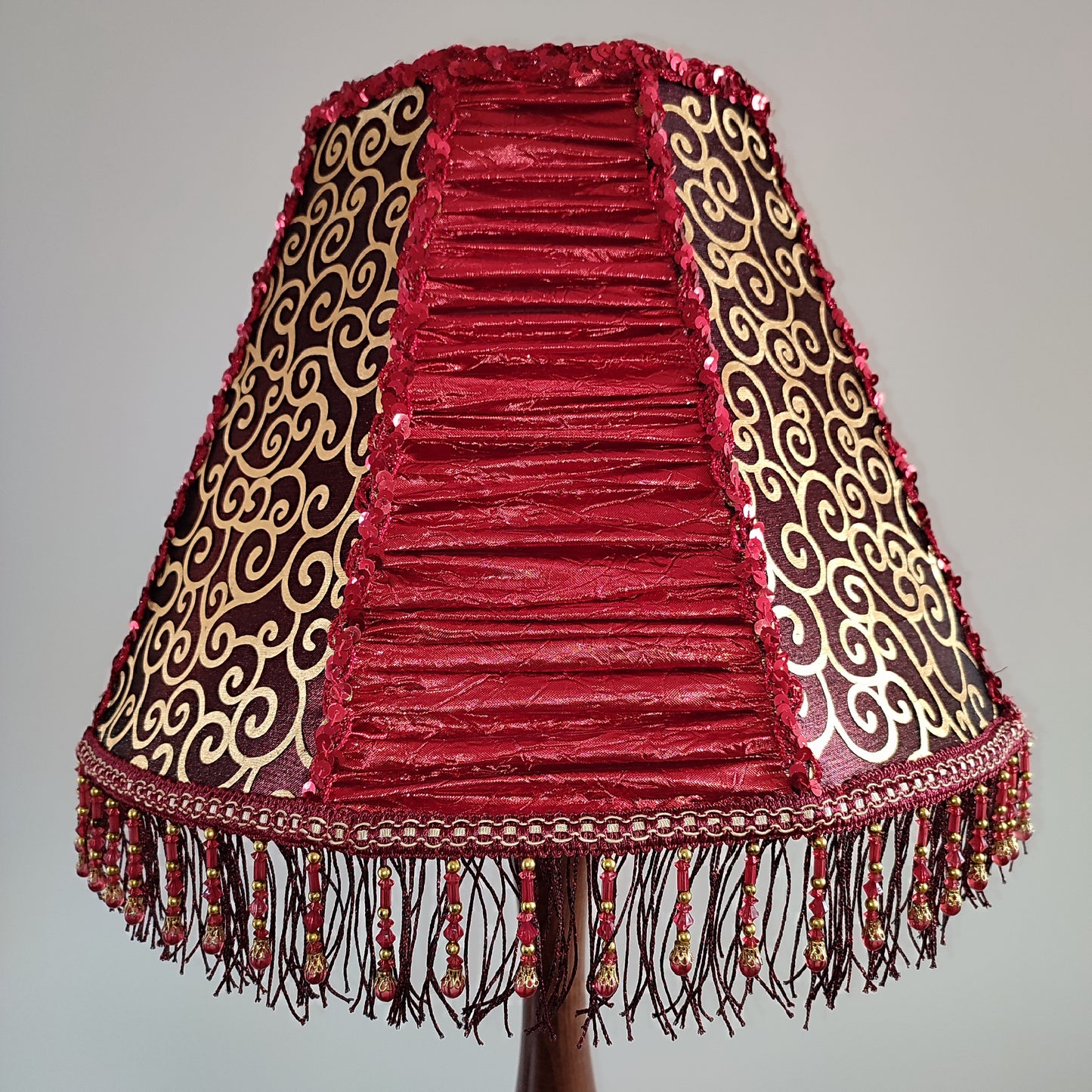 A burgundy lampshade with a swirling pattern and beaded fringe.Unique lamp, handcrafted laтббmp, decorative lamp. 1116