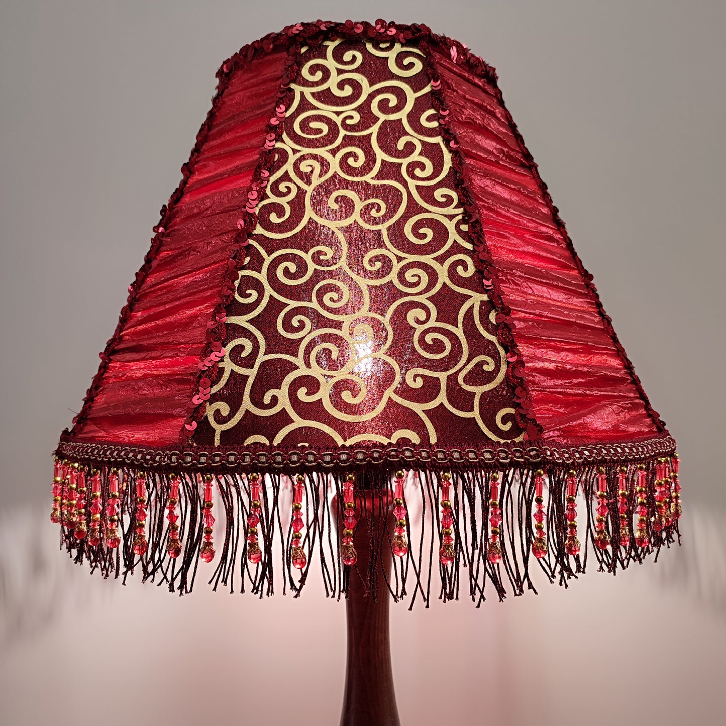 A burgundy lampshade with a swirling pattern and beaded fringe.Unique lamp, handcrafted laтббmp, decorative lamp. 1116