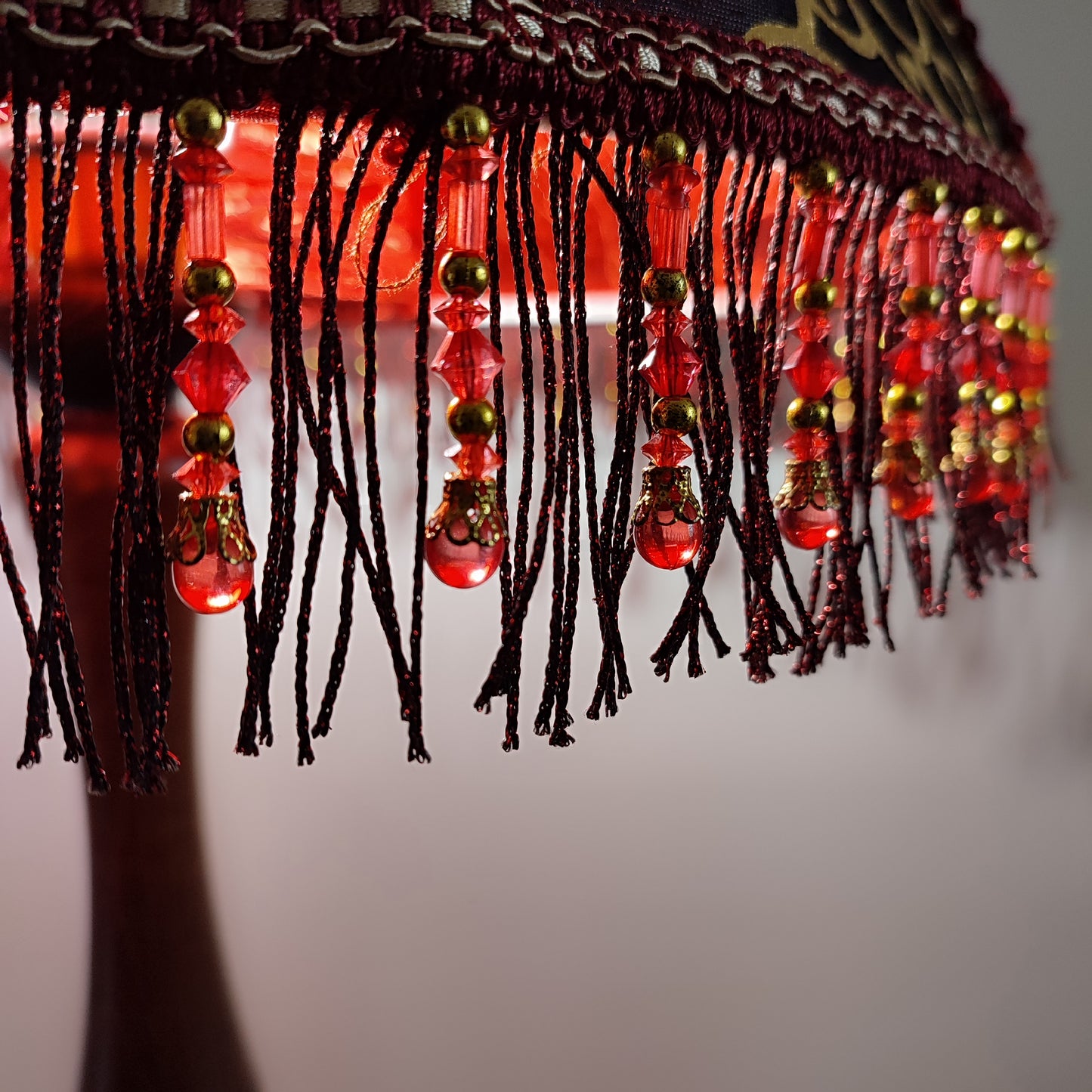 A burgundy lampshade with a swirling pattern and beaded fringe.Unique lamp, handcrafted laтббmp, decorative lamp. 1116