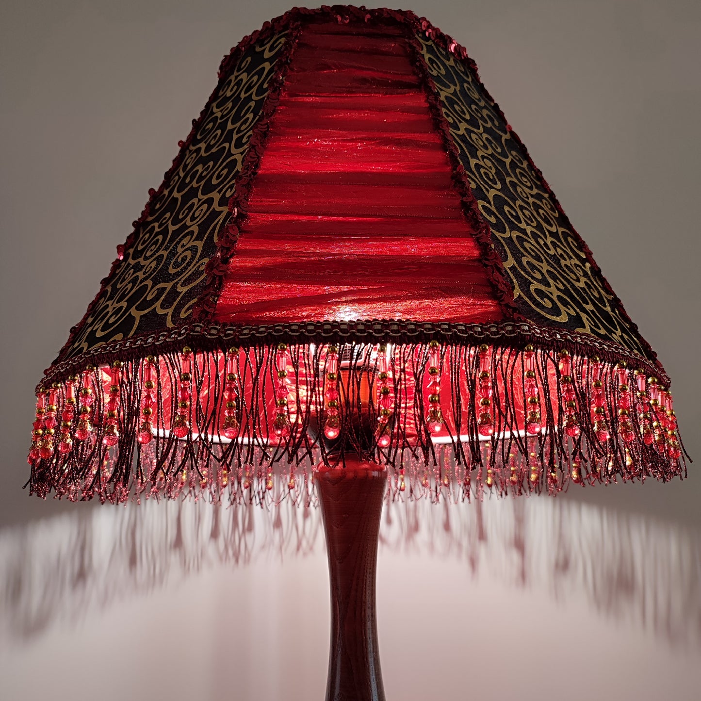 A burgundy lampshade with a swirling pattern and beaded fringe.Unique lamp, handcrafted laтббmp, decorative lamp. 1116