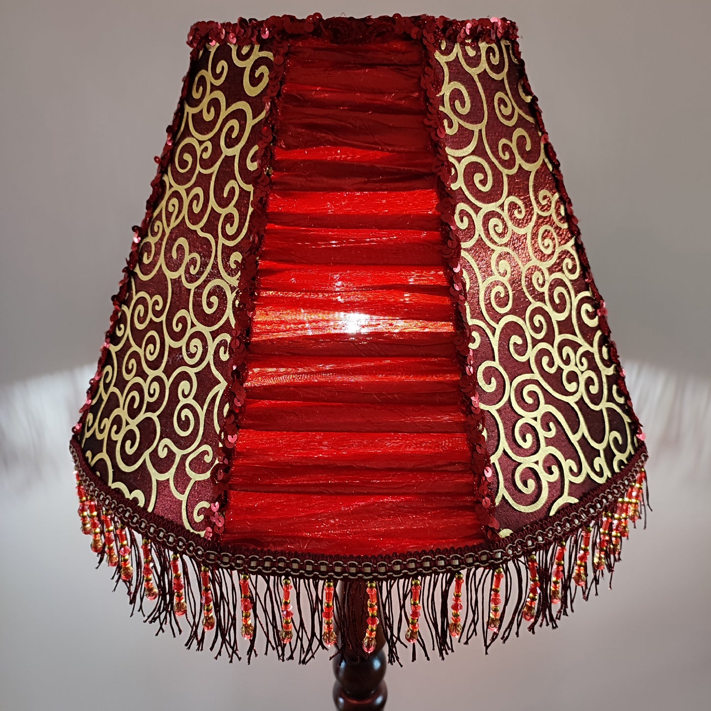 A burgundy lampshade with a swirling pattern and beaded fringe.Unique lamp, handcrafted laтббmp, decorative lamp. 1116