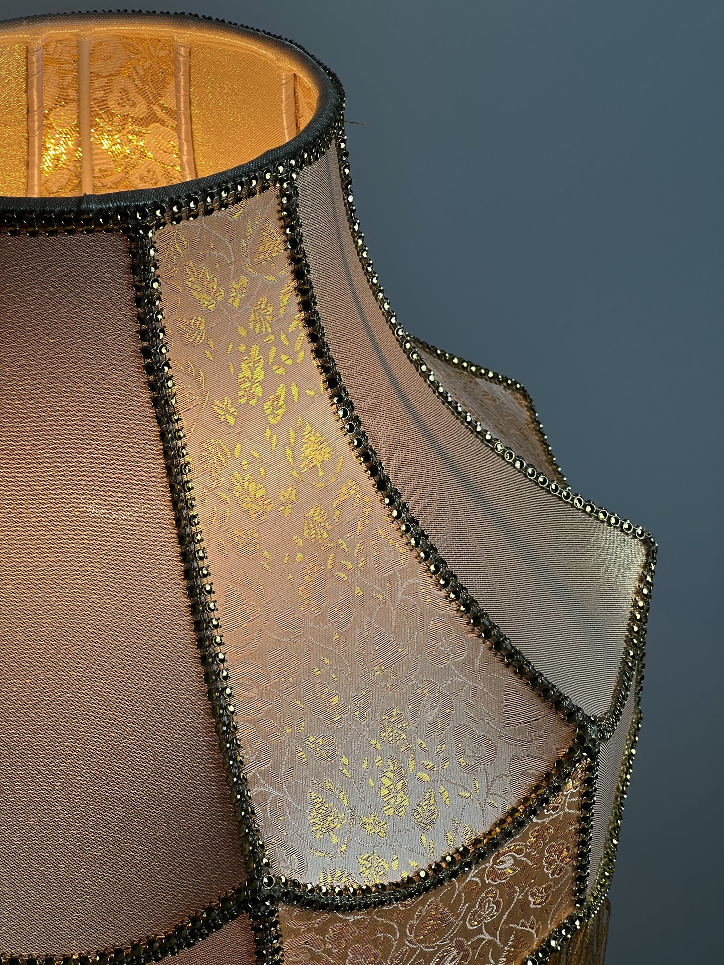 Gold-colored table lamp with elegant lace details and tasseled fringe. 7202