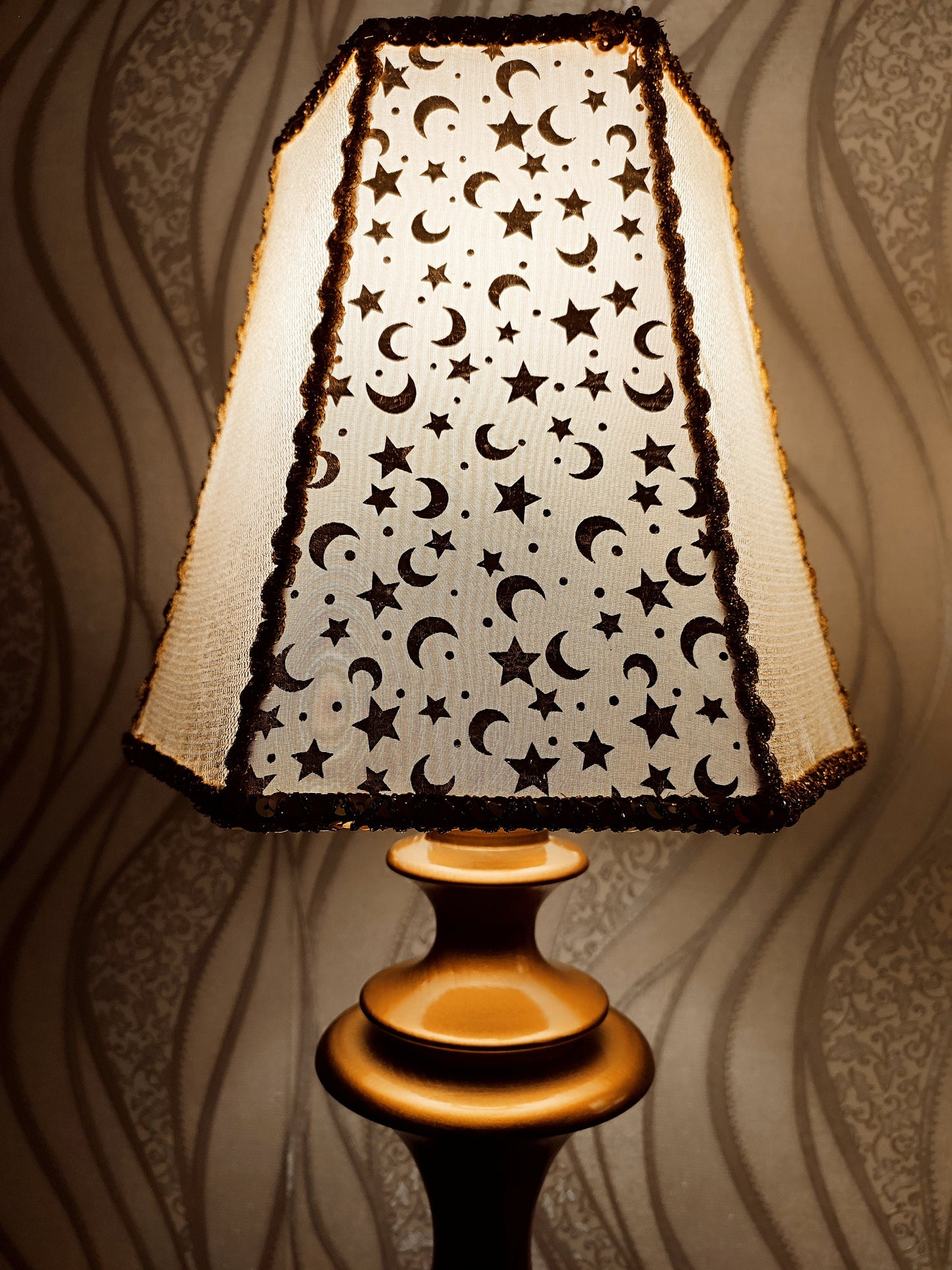 Table lamp. Golden celestial lamp with shimmering moons and stars on a delicate fabric. The wooden base is bronze in color. 7701