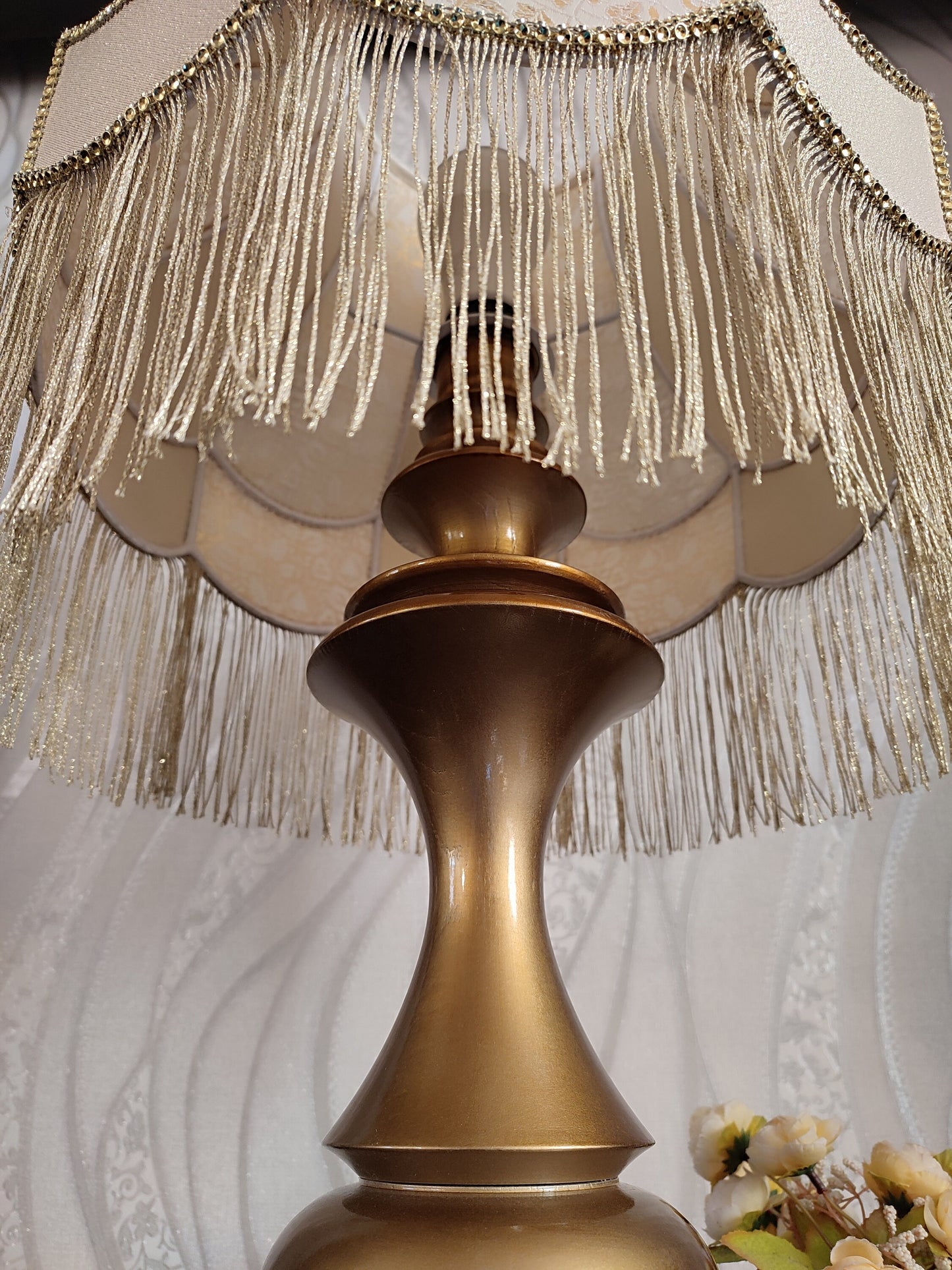 Gold-colored table lamp with elegant lace details and tasseled fringe. 7202