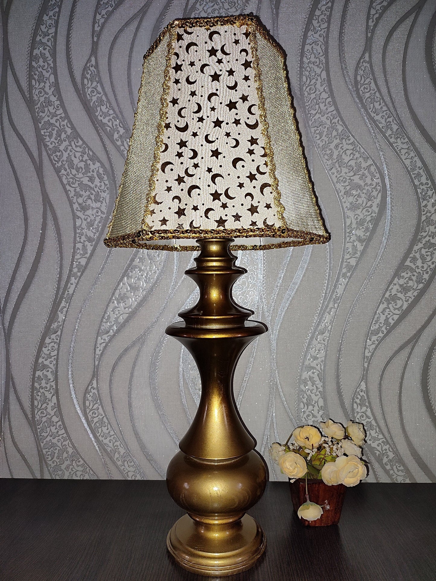 Table lamp. Golden celestial lamp with shimmering moons and stars on a delicate fabric. The wooden base is bronze in color. 7701