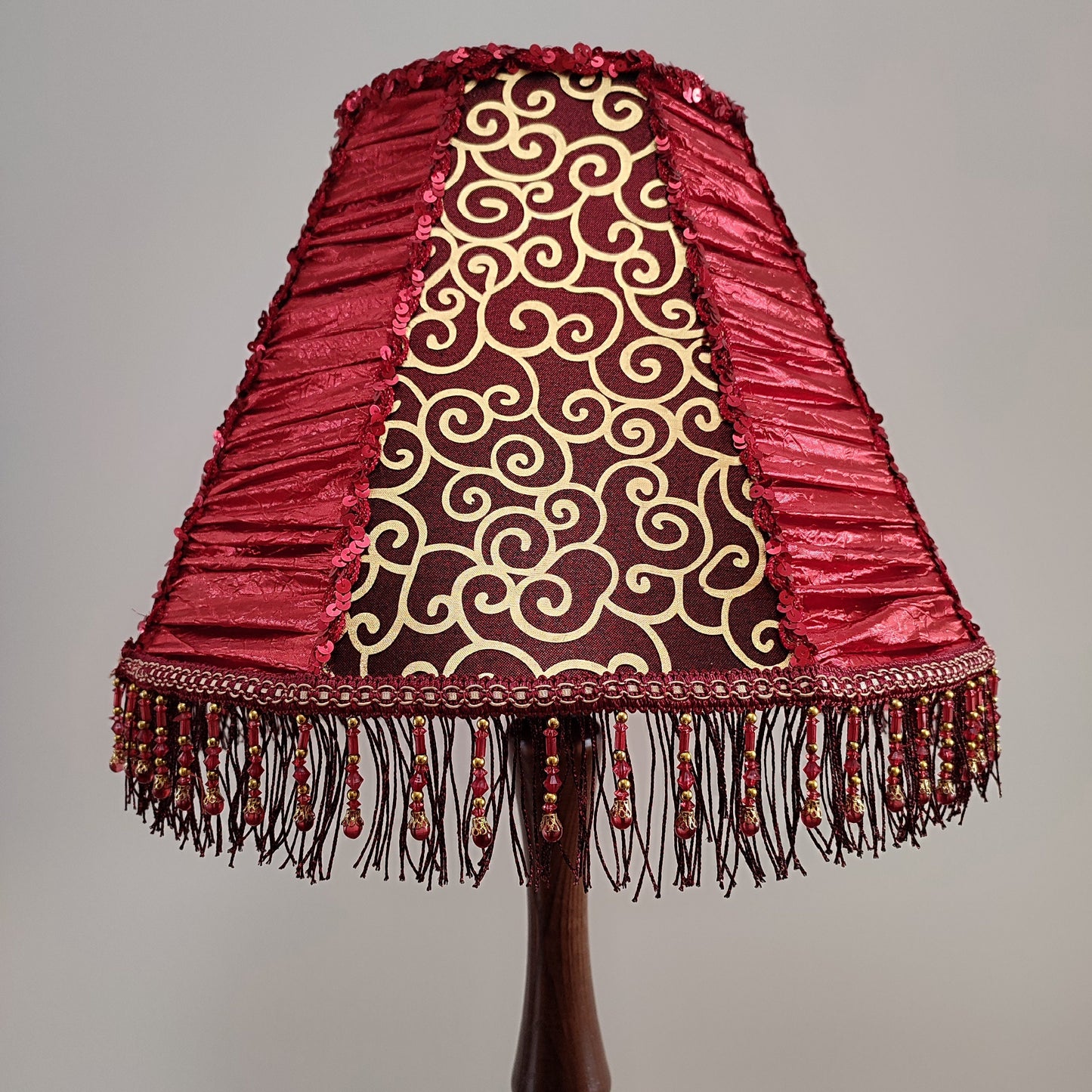 A burgundy lampshade with a swirling pattern and beaded fringe.Unique lamp, handcrafted laтббmp, decorative lamp. 1116