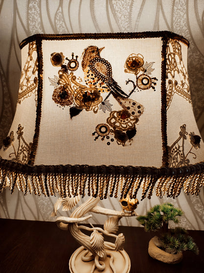 Lampshade. A unique lampshade with an embroidered bird and crocheted flowers.