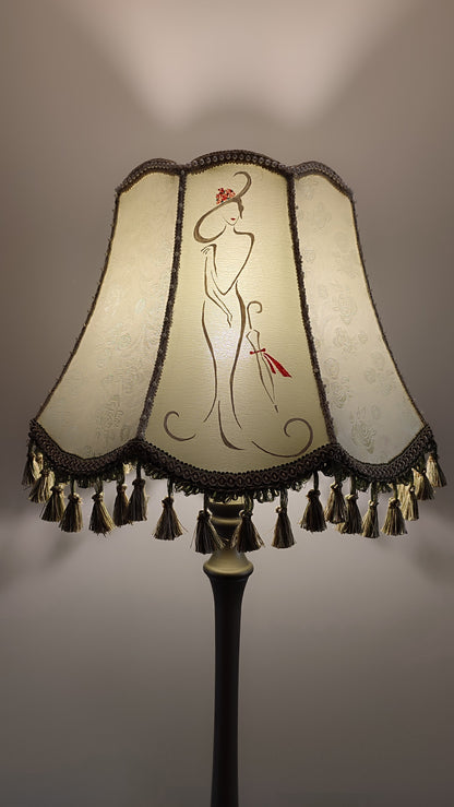 A Victorian floor lamp with a fabric shade and an exquisite floral umbrella motif with tassels.