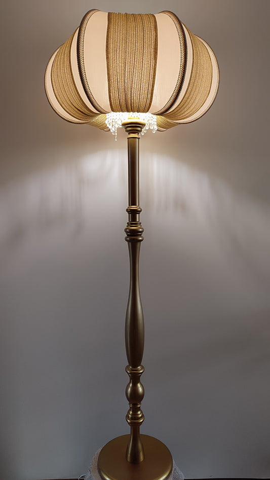 A two-tone creamy golden lampshade, delicate crystal beads and an elegant wooden base add a touch of luxurious radiance