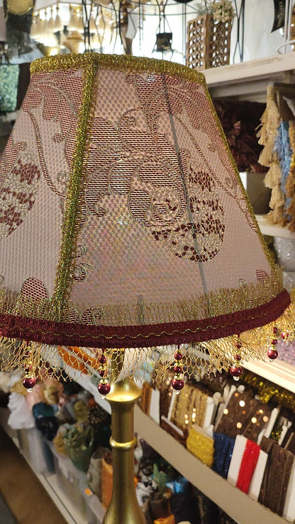 Handcrafted floor lamp with a burgundy shade featuring a floral pattern and beaded fringe . № 7108