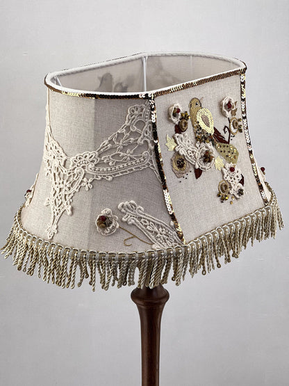 Lampshade. A unique lampshade with an embroidered bird and crocheted flowers.