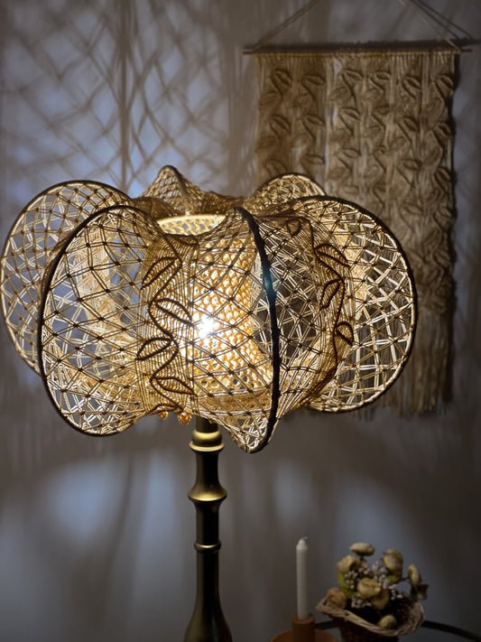 A unique macrame lampshade with a complex panel design.