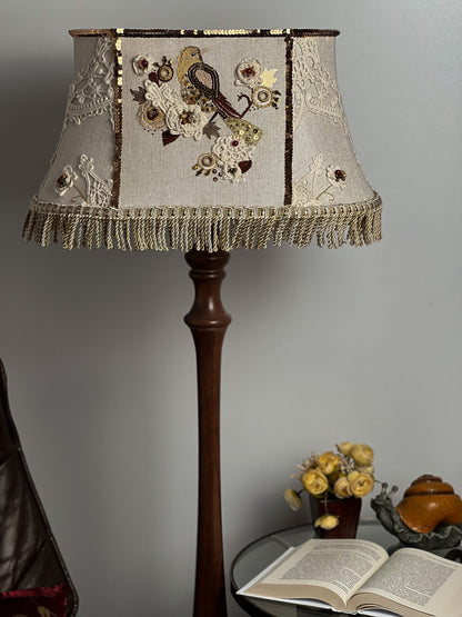 Lampshade. A unique lampshade with an embroidered bird and crocheted flowers.