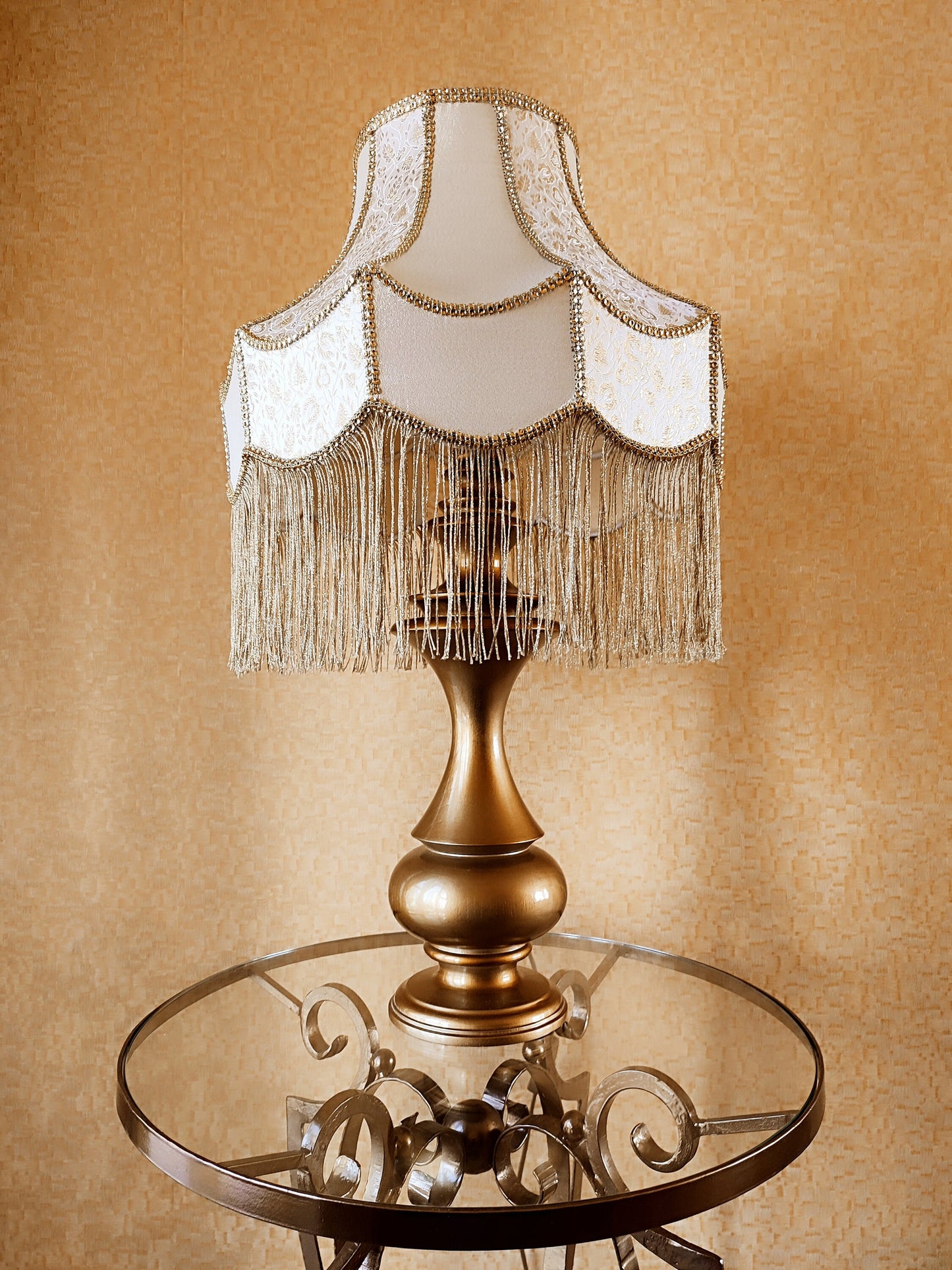 Gold-colored table lamp with elegant lace details and tasseled fringe. 7202