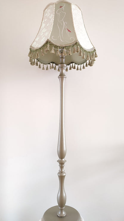 A Victorian floor lamp with a fabric shade and an exquisite floral umbrella motif with tassels.