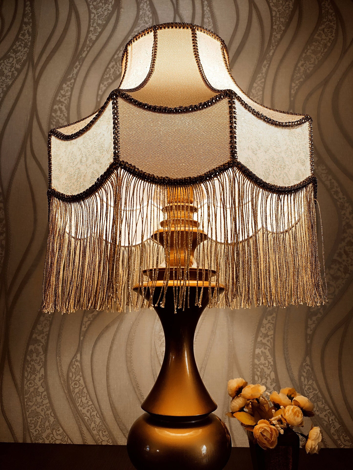 Gold-colored table lamp with elegant lace details and tasseled fringe. 7202