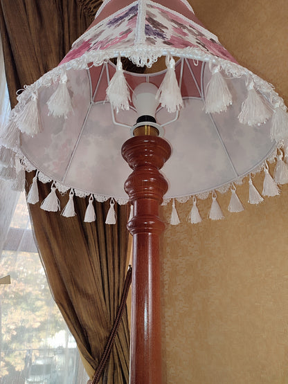 Floor lamp, pastel pink top, blooming flower shade, delicate fringe with tassels, on an elegant wooden base. 3601