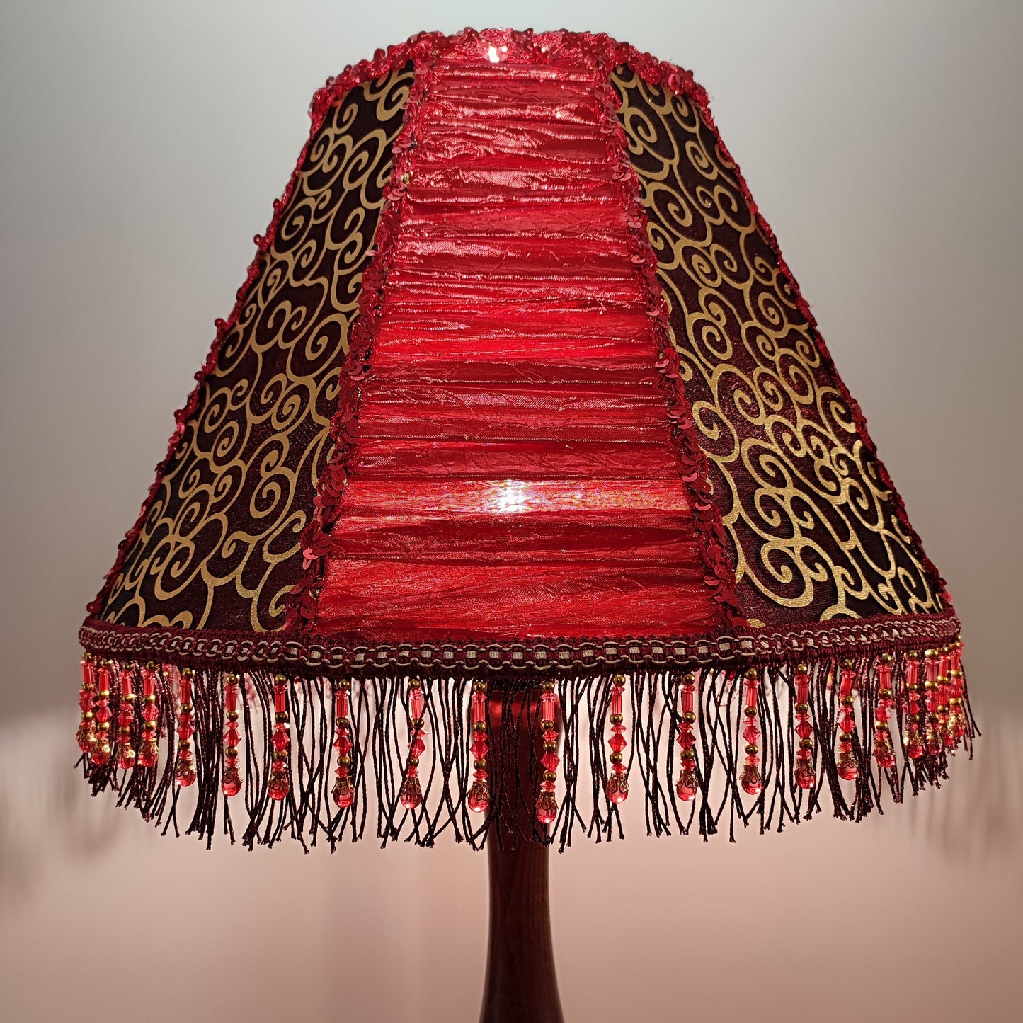 A burgundy lampshade with a swirling pattern and beaded fringe.Unique lamp, handcrafted laтббmp, decorative lamp. 1116