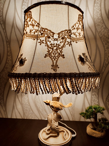 Lampshade. A unique lampshade with an embroidered bird and crocheted flowers.